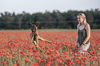 woman with  Malinois in the poppy field