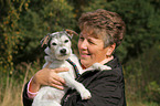 woman carries a Parson Russell Terrier