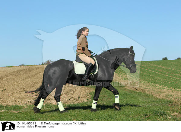 woman rides Friesian horse / KL-05013