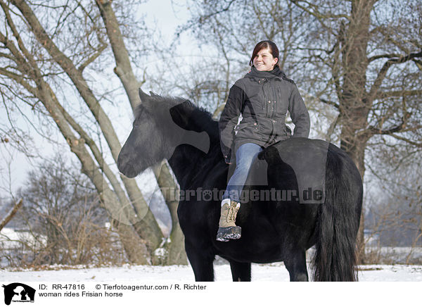 woman rides Frisian horse / RR-47816