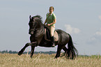 woman rides Frisian horse