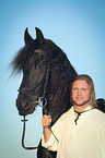 man and Frisian horse
