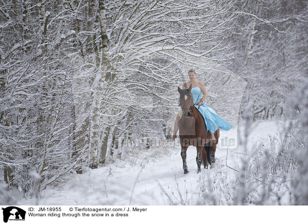 Woman riding through the snow in a dress / JM-18955