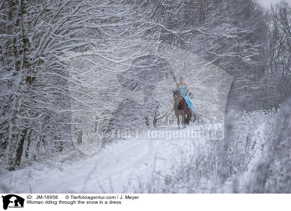 Woman riding through the snow in a dress / JM-18956